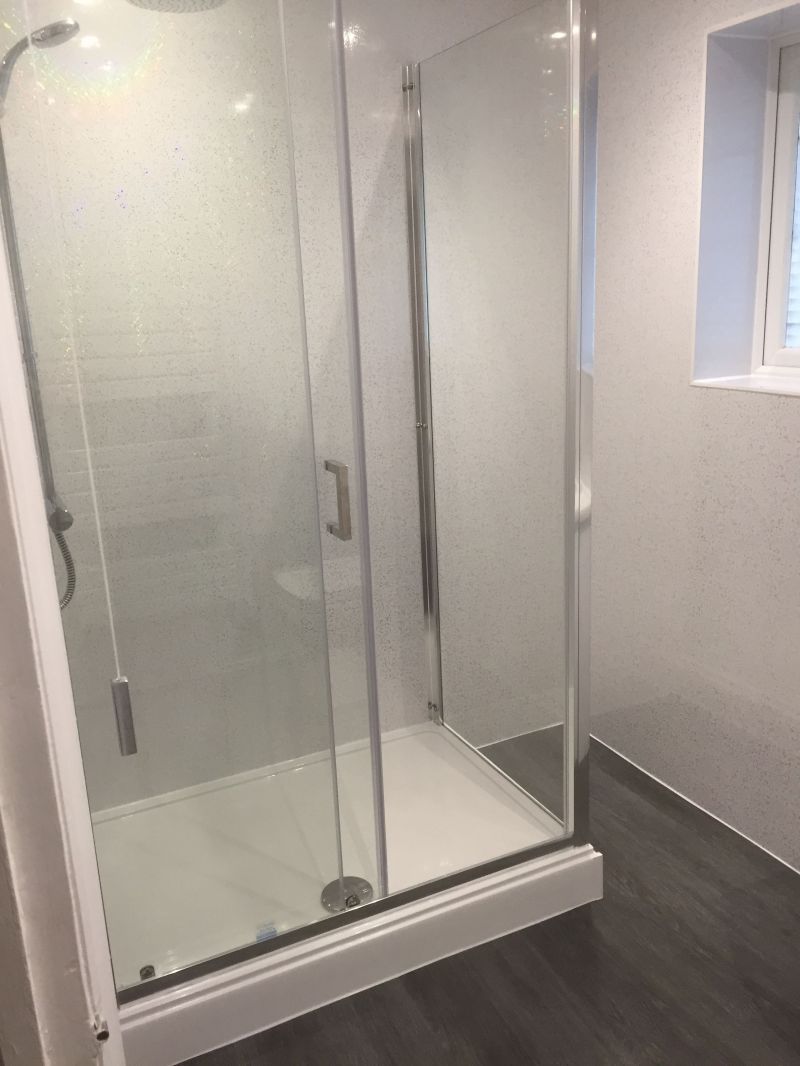 Shower Room with walk in chrome cubicle, Mira thermostatic shower, vanity unit & toilet set, white towel rail.  White sparkle UPVC Cladding, Dark Grey Livyn Click flooring.: Swipe To View More Images