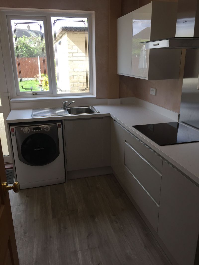 Wren Gloss Pebble base units and Gloss White wall units with White Sparkle worktop and upstands.  Light Grey Vinyl Click Flooring.: Swipe To View More Images