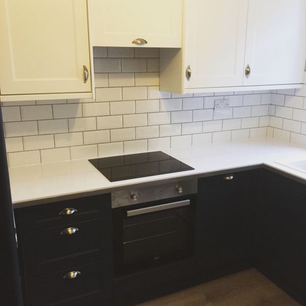 B&Q Dark Blue and Bright White Kitchen range, White Worktops, Grey Vinyl Flooring and White Brick effect tiling with Manhattan Grey grout.: Swipe To View More Images
