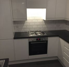 Howdens Clerkenwell range in white gloss finish, Basalt Slate honed worktops, White brick effect tiling and Quick Step Livyn Dark Grey Oak Vinyl flooring and Bosch appliances.: Click Here To View Larger Image