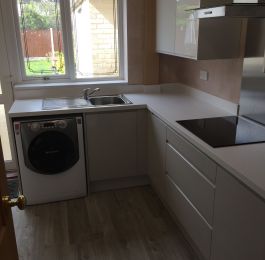 Wren Gloss Pebble base units and Gloss White wall units with White Sparkle worktop and upstands.  Light Grey Vinyl Click Flooring.: Click Here To View Larger Image