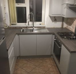 Homebase Gloss Grey Handleless Kitchen range with Ink Bark worktop and Indesit appliances.: Click Here To View Larger Image
