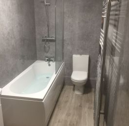 Shower Bath and suite with Grey concrete effect wetwall throughout.  : Click Here To View Larger Image